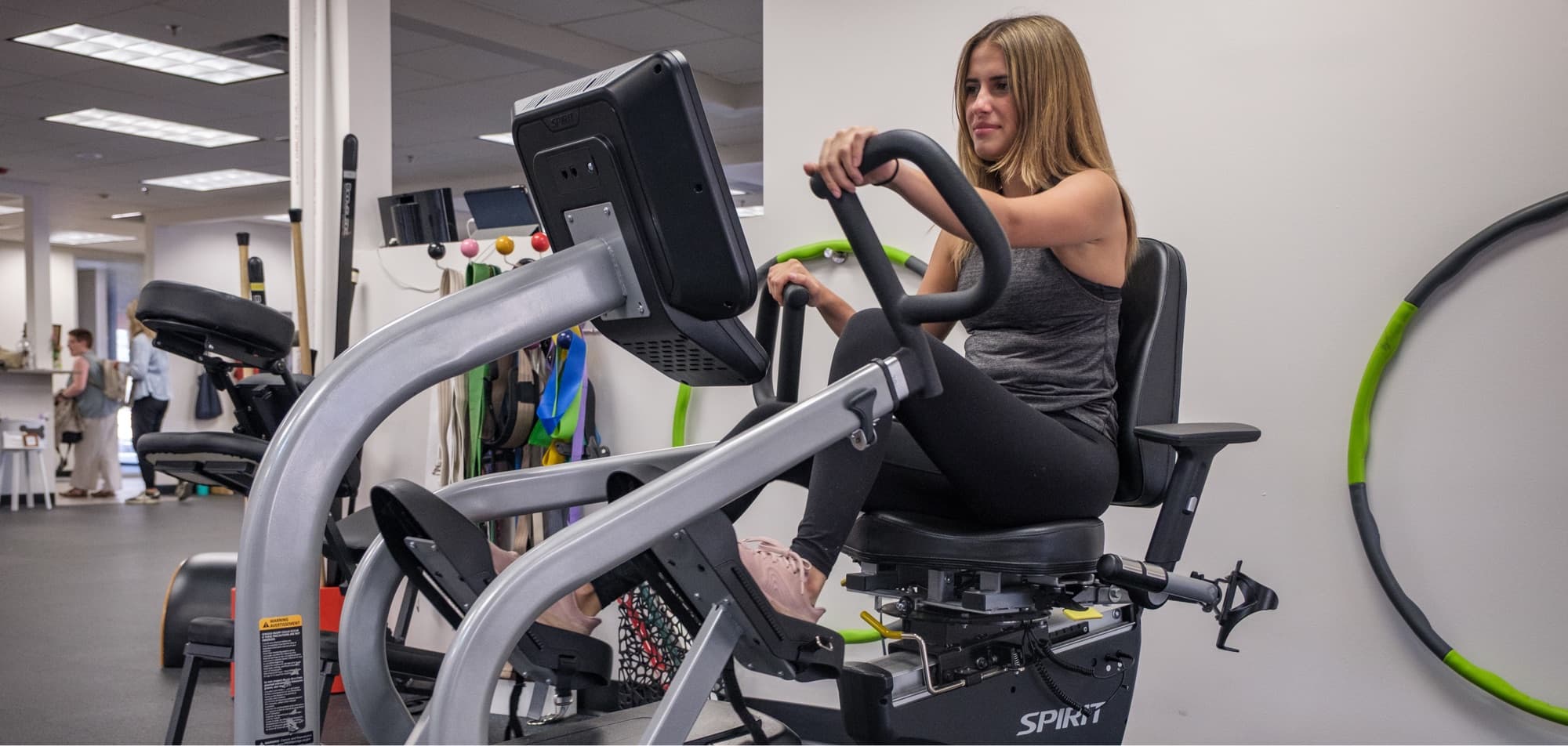 A patient training on a recumbent bike at Alliance Physical Therapy
